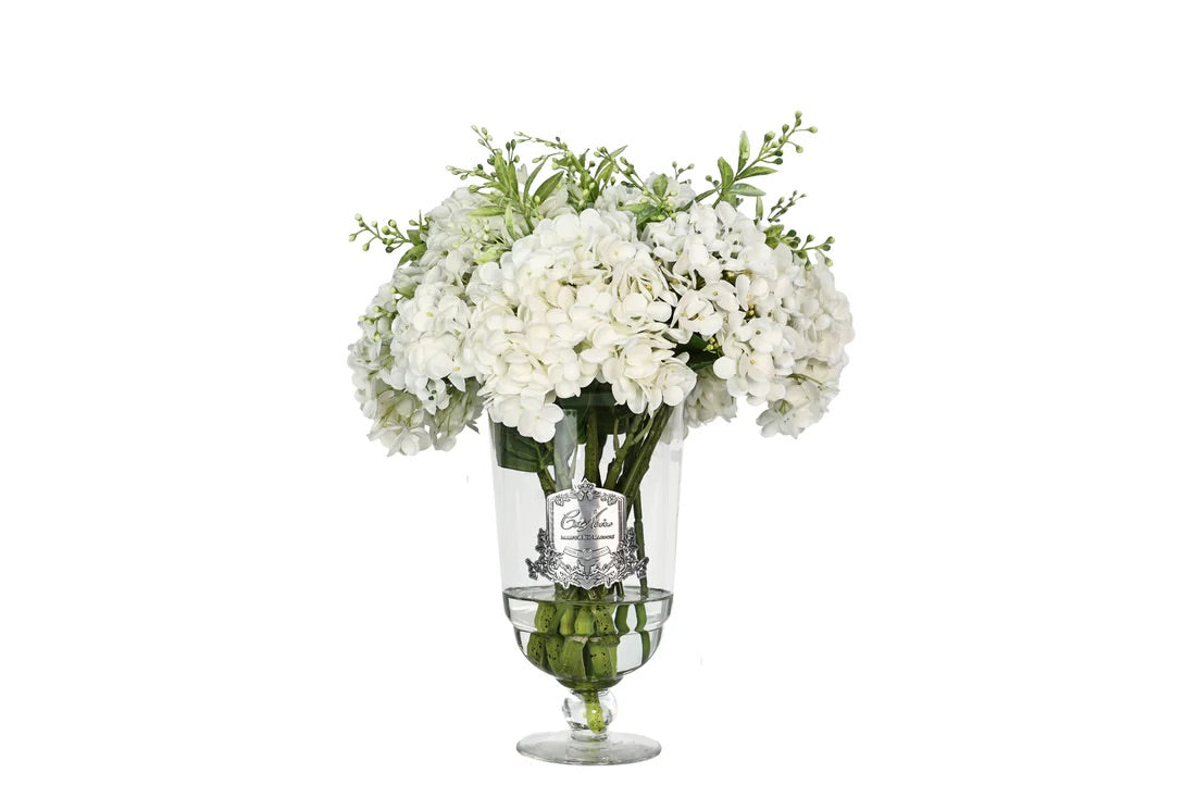 Bouquet décoratif Grand Summer composé d’hortensias blancs réalistes et de feuillage vert, présenté dans un vase en verre gravé Côté Noire.