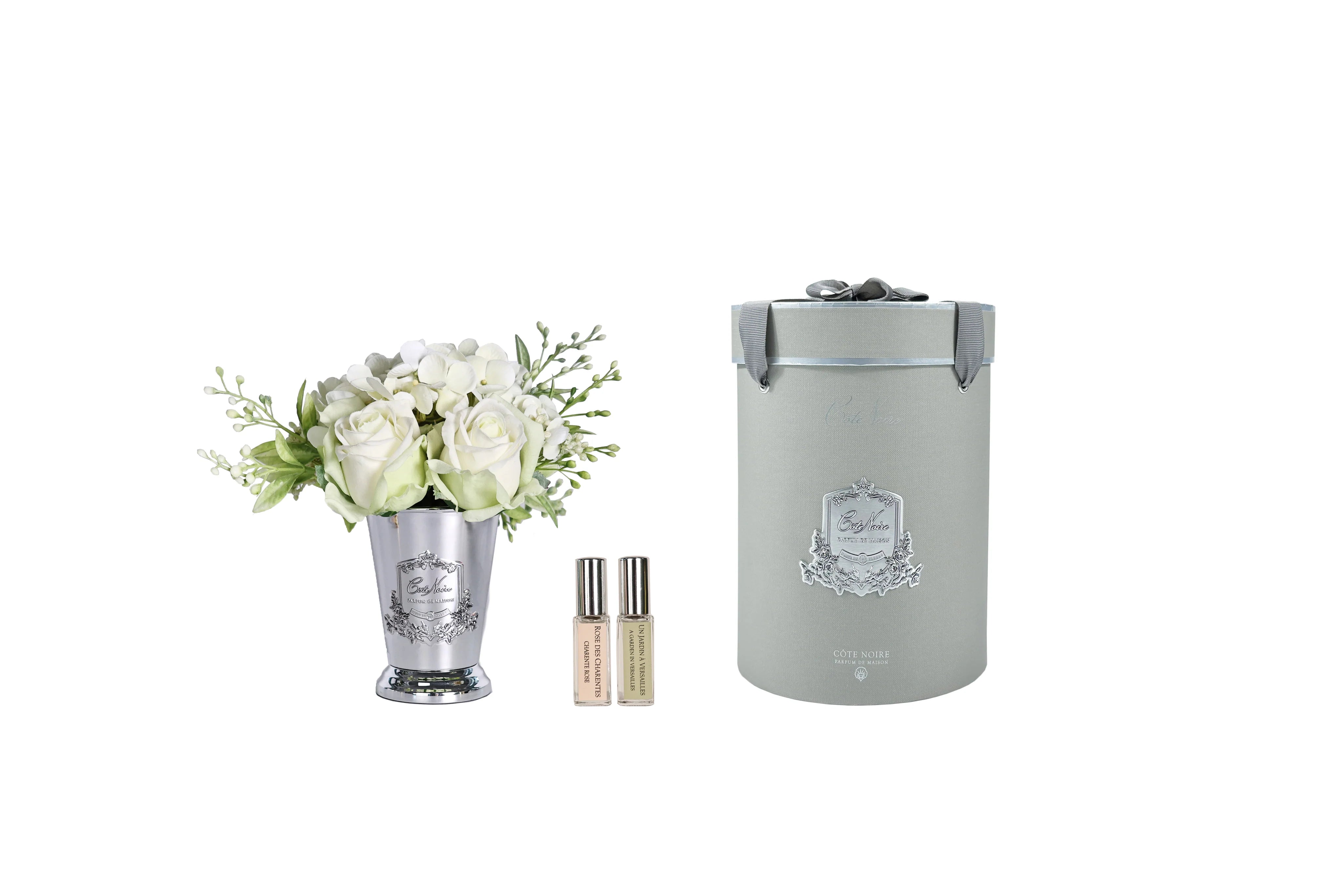 Bouquet réaliste "Seven" avec hortensias blancs et feuillage vert dans vase argenté Côté Noire, présenté en décoration intérieure.